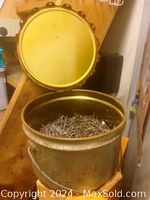 Opened metal bucket showing lid and bulk nails inside