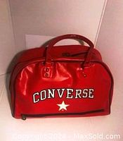 Front view of shiny red Converse sports bag with white logo and star.