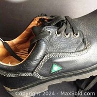 Close-up side view of one black Dakota Quad Comfort CSA approved safety shoe showing leather texture, stitching, and green CSA symbol badge.