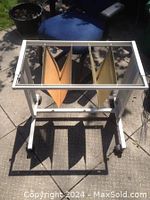 Top-down image of beige metal filing system showing adjustable frame and hanging file folders inside.