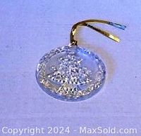 Clear glass or crystal circular Christmas tree ornament by Mikasa with embossed design and gold hanging cord.