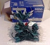 Photo of the 50 clear mini lights loosely coiled with plug visible and original blue box labeled 'MINI LIGHTS' and '50 lights CLEAR'.