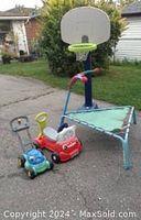 Photo showing basketball net with base in background, triangular bouncer trampoline, toy lawn mower, and red and white ride-on toy car.