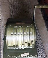 Close-up of the vintage mechanical Pay Master cheque writing device with sliding levers for dollars and cents