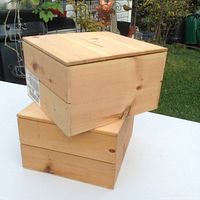 Two stacked unstained light pine wine boxes with lids, showing natural wood grain, knots, and a smooth finish outdoors.