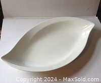 Top and angled views of white ceramic oval platter 14 x 10 inches showing smooth glossy finish and curved edges
