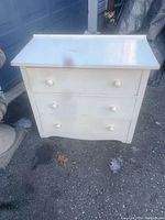 Front view of vintage white wooden chest of drawers with three drawers and round knobs showing used condition.