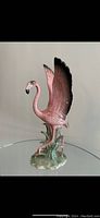 Side view of pink flamingo figurine showing full wing span and base details.