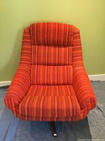 Front view of scoop chair showing orange striped fabric upholstery and metal swivel base