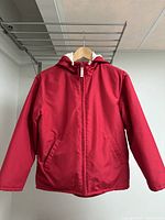 Front view of red fleece lined jacket showing full zipper and pocket details