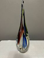 Front view of tapered glass vase showing curved teardrop shape and color swirls.