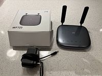 ZTE WF723 modem with two antennas, charger, and box on table.