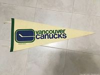 Full view of the Vancouver Canucks hockey pennant showing full logo and text.