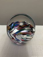 Front view of the glass swirl paperweight showing the colorful swirls and bubbles inside the clear glass dome.
