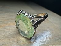 Angled view showing oval green stone and gold band details