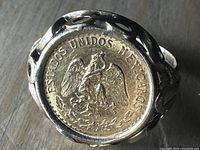 Front view showing ring mounting a 1945 Mexican Dos Pesos coin with eagle emblem and 'ESTADOS UNIDOS MEXICANOS' legend.