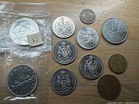 Photo of assorted Canadian coins including uncirculated 1968 dollar and Ontario token in plastic bag, half dollars, smaller dated coins
