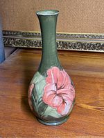Front view of tall green Moorcroft vase with pink floral design