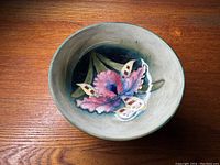 Top view showing interior floral design with pink and purple flower and green leaves on dark blue background.