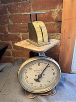 Close-up of large Landers, Frary & Clark postal scale with round dial and metal platform, showing weight up to 4 lbs