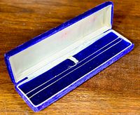 Full view of the 10k white gold chain necklace in a blue velvet-lined jewelry box on a wooden surface.