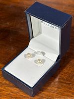 Pearl stud earrings displayed in a navy blue jewelry box with white interior, labeled Hudson's Bay.
