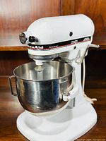 White KitchenAid Professional tilt-head stand mixer assembled with 6-quart stainless steel bowl and flat beater attachment