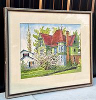Full view of framed and matted watercolour painting depicting an old house with a red roof and green siding, showing the artwork and frame.