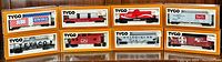 Eight TYCO HO scale boxcars in original boxes, arranged in two rows showing front views of different advertising liveries including Ralston Purina, Texaco, Coca-Cola, CN, Virginian, and others.