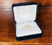 Ring seated in a black velvet Market Square Jewelers presentation box on wood surface