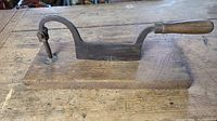 Full view of the antique metal tobacco leaf cutter mounted on oak chopping board showing overall condition and shape