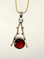 Close-up front view of the fire garnet pendant mounted in sterling silver with gold plating.