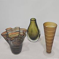 All three vases together showing the shapes and colors: multicolored ruffled handkerchief vase, green teardrop vase, and gold Sasaki vase