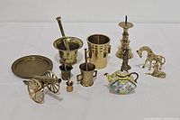 Full view of all 13 assorted brass pieces including figurines, kitchenware items, and decorative pieces.