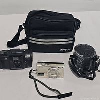 All lot contents shown: Minolta Freedom Zoom 70c film camera, Nikon COOLPIX S6100 digital camera, Minolta branded camera pouch, black lens case.