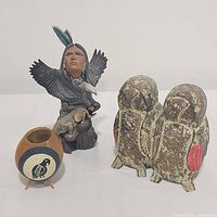 Front view of all three decorative items together: ceramic figurine, wooden birds, and footed bowl