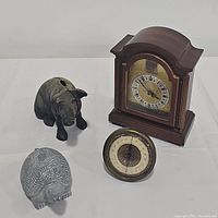 Photo shows the full lot: vintage wooden mantel clock, cast iron pig bank, sandstone turtle figurine, brass temperature gauge on white background.