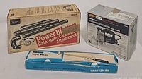 Lot items in their original packaging including the Craftsman torque wrench box, Power Bl rain gutter cleanout attachment box, and Craftsman electronic auto scroller saw box showing product details.
