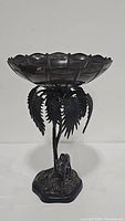 Overall side view of bronze metal sculpture compote showing bowl, palm tree, and camel base.