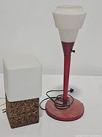 Overview of both lamps: cork block lamp with white cube shade and red candlestick lamp