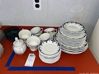 View of stacked Adams ironstone dishes including plates and mugs with floral decoration, showing quantity and condition.