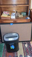 Photo showing Royal HG120 shredder, bulletin board, and office supplies on wooden shelf.
