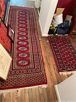 Photo showing both runners side by side on wooden floor with some household items nearby.