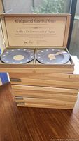Stack of seven original boxed Wedgwood State Seal Series decorative plate sets, sets 1 to 7, each box contains two Jasperware plates depicting seals of original thirteen states.