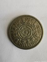 Reverse side of the 1953 two shillings coin showing floral design and denomination.