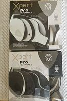 Front view of two boxed Xpert Pro foldable headphones, black and white models, showing branding and foldable feature on the boxes.