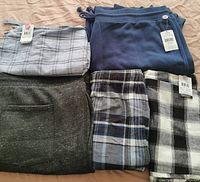 Five men's bottoms in size 2XL including plaid shorts, pajama pants, and joggers, all new with tags.
