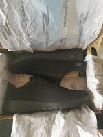 Black Skechers Performance men's shoes inside the box, showing the side profile and mesh upper.