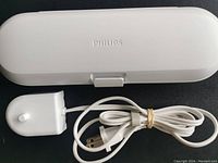 Closed white Philips travel case and charger power cord with plug