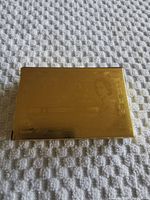 Playing card box front displaying embossed and gold plated Canadian $1000 bill design showing Queen Elizabeth II portrait and currency details.